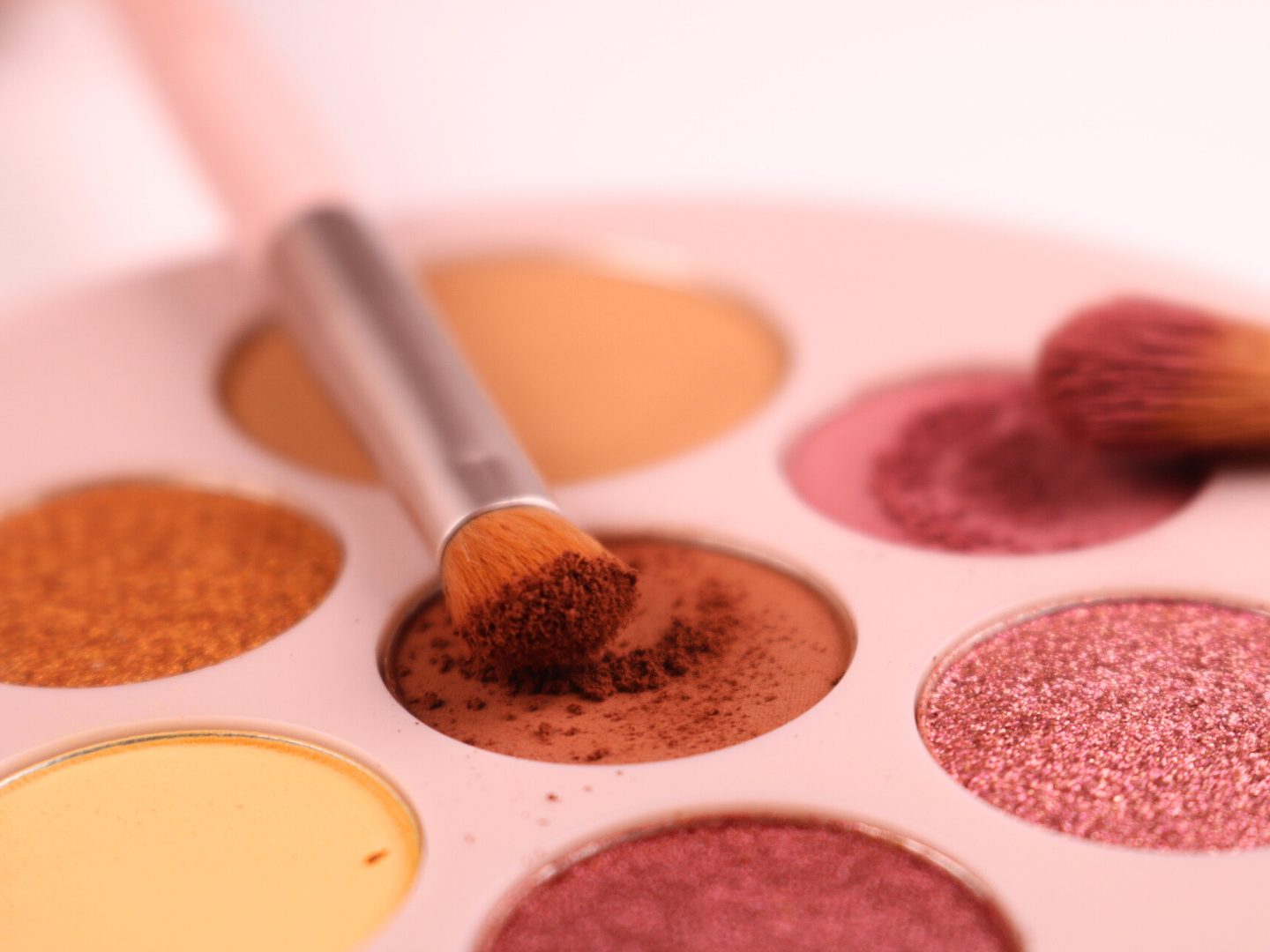 Makeup palette with colorful eyeshadows and a brush