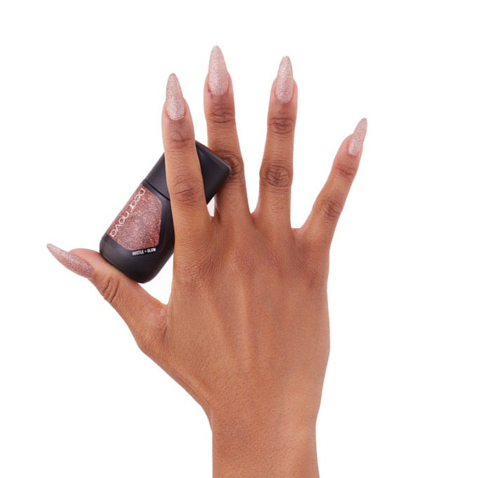 brown skin hand model holding bottle of nail lacquer with almond shaped painted nails