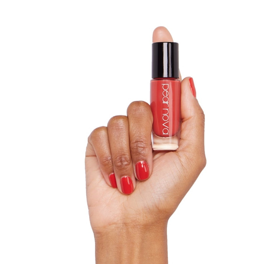 brown skin hand model holding bottle of nail lacquer with Sorry I'm Late painted nails