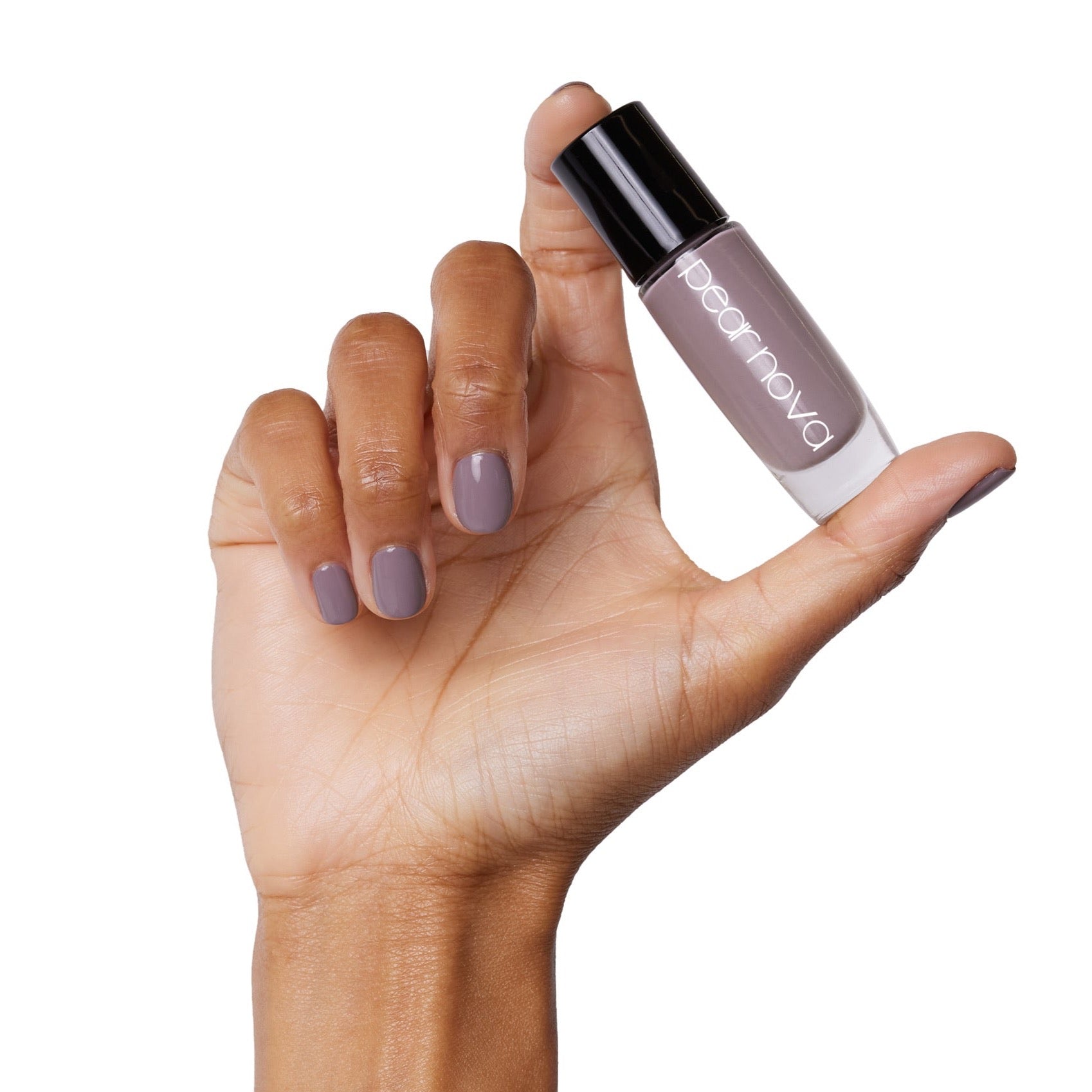 brown skin hand model holding bottle of nail lacquer with natural taupe painted nails 