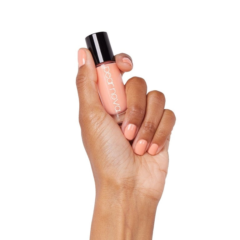 brown skin hand model holding bottle of nail lacquer with Pink It Through painted nails 