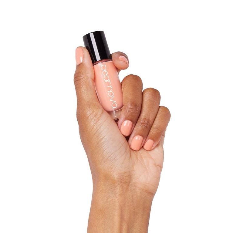 brown skin hand model holding bottle of nail lacquer with Pink It Through painted nails