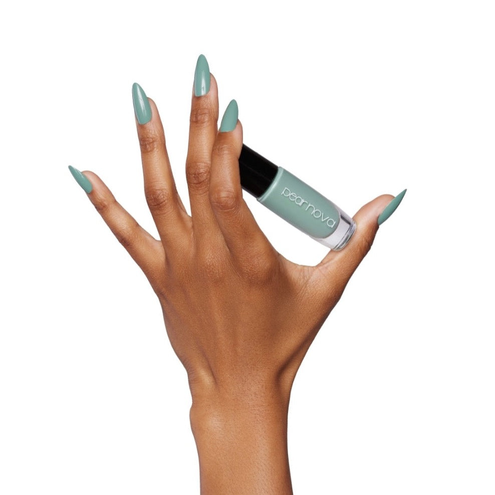 brown skin hand model with almond nails holding bottle of aloe-ha fern green nail polish