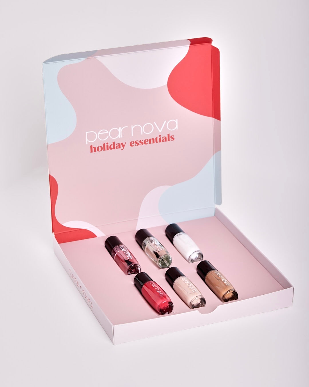 open box of holiday essentials nail set showing top coat, cuticle oil, base coat, and three nail polishes on display