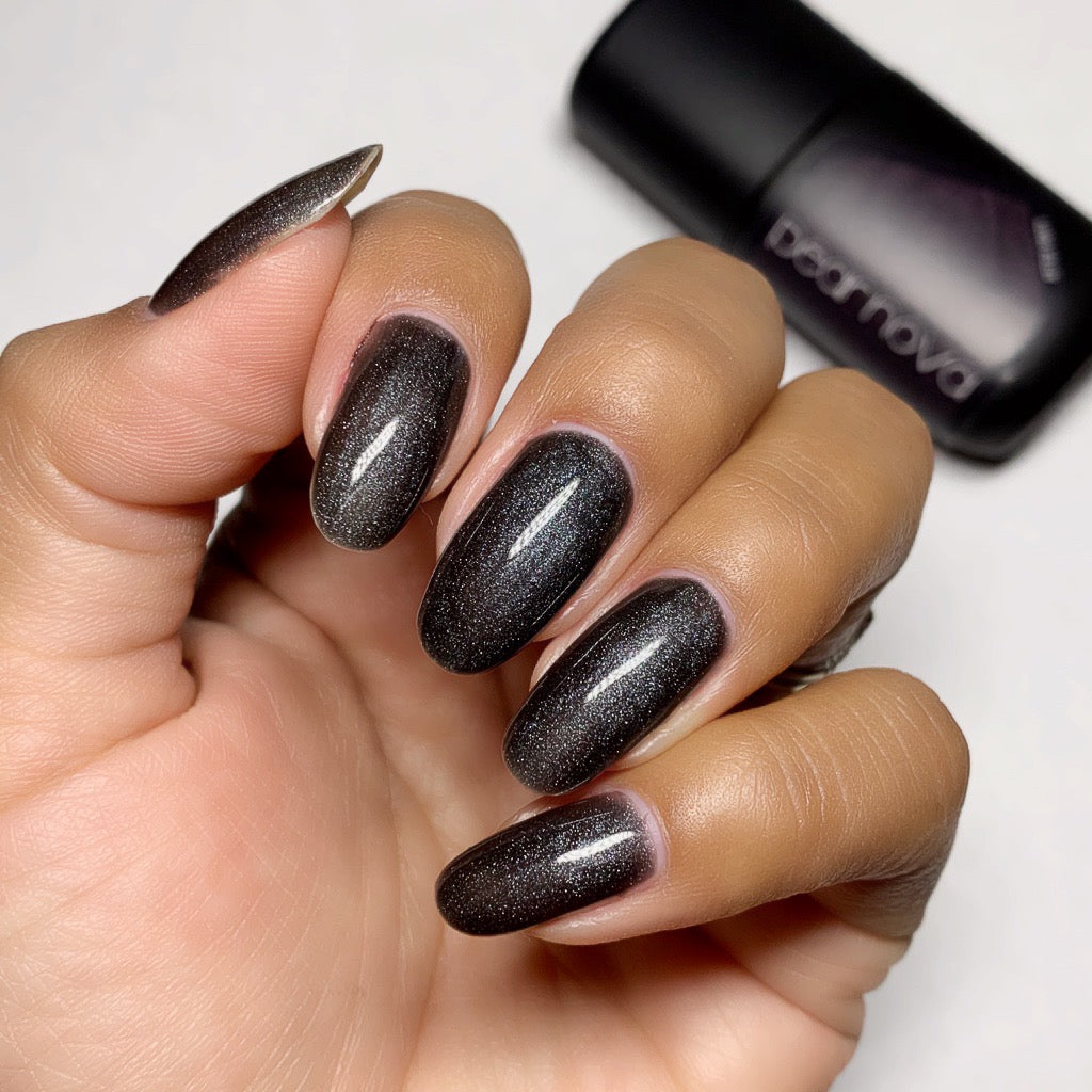 light brown skin hand model with dark grey shimmer nail polish on round nails