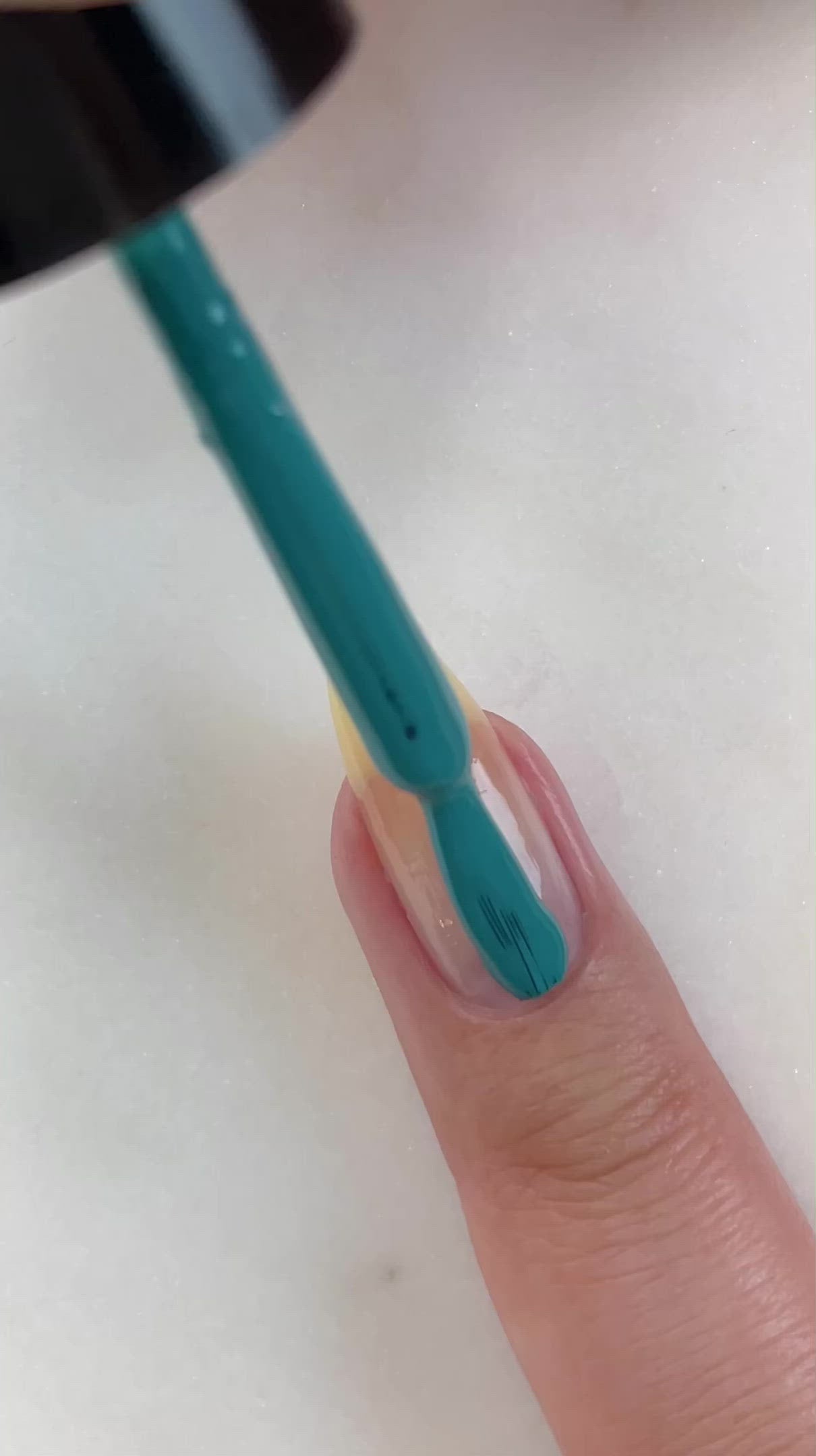 video of fair skin hand model painting nails with turquoise nail lacquer