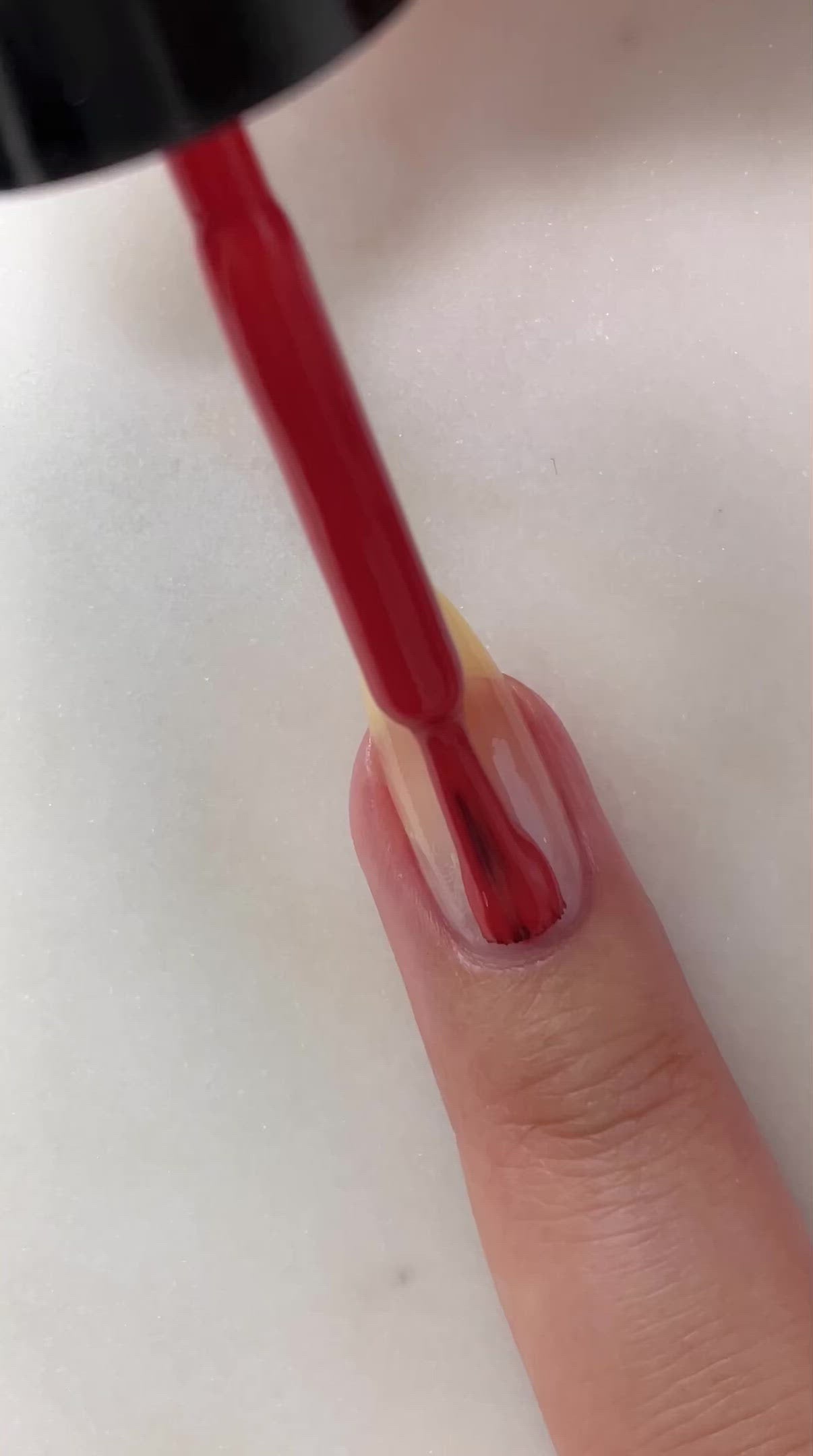 video of fair skin hand model painting nails with nail lacquer showing smooth application and finished product