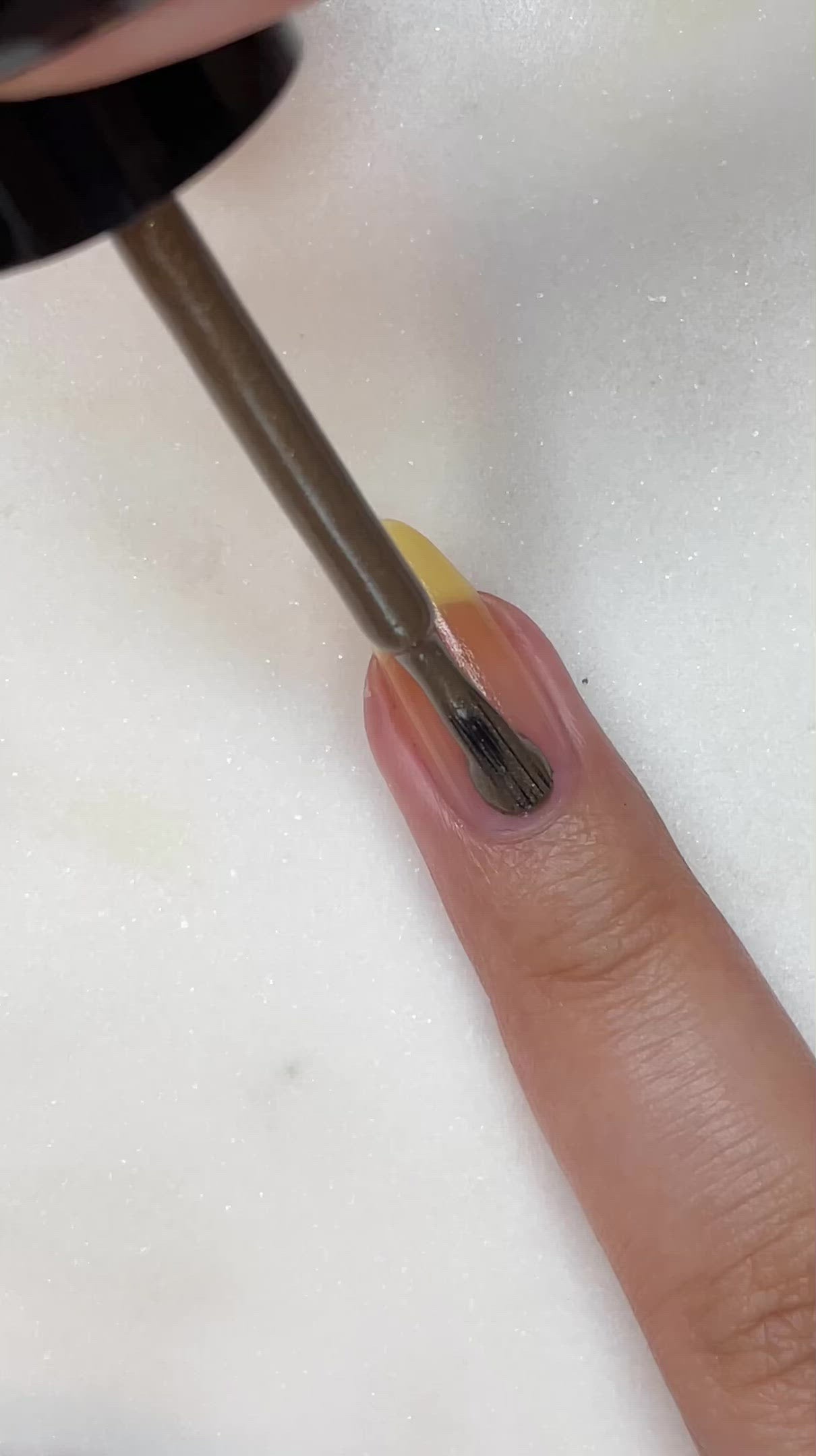 video of fair skin hand model painting nails with bronze nail lacquer
