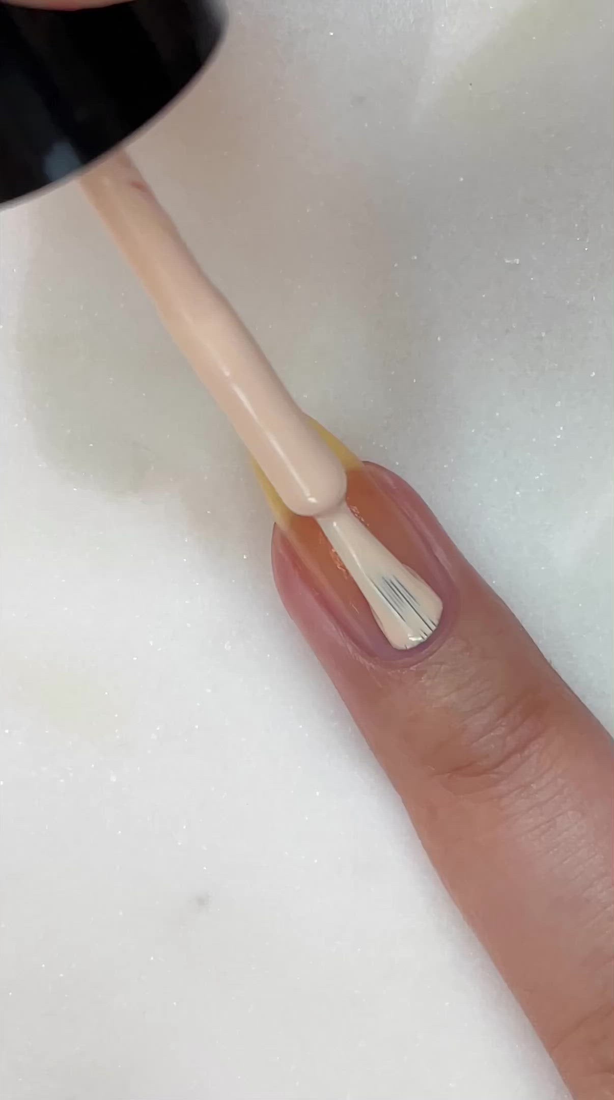 video of fair skin hand model painting nails with nail lacquer showing smooth application and finished product