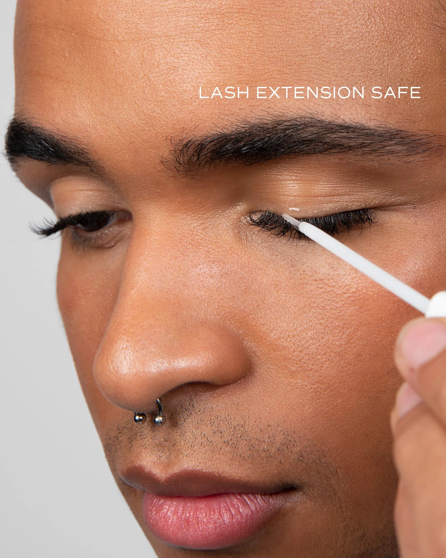 close up of model eye showing long lashes applying lash serum