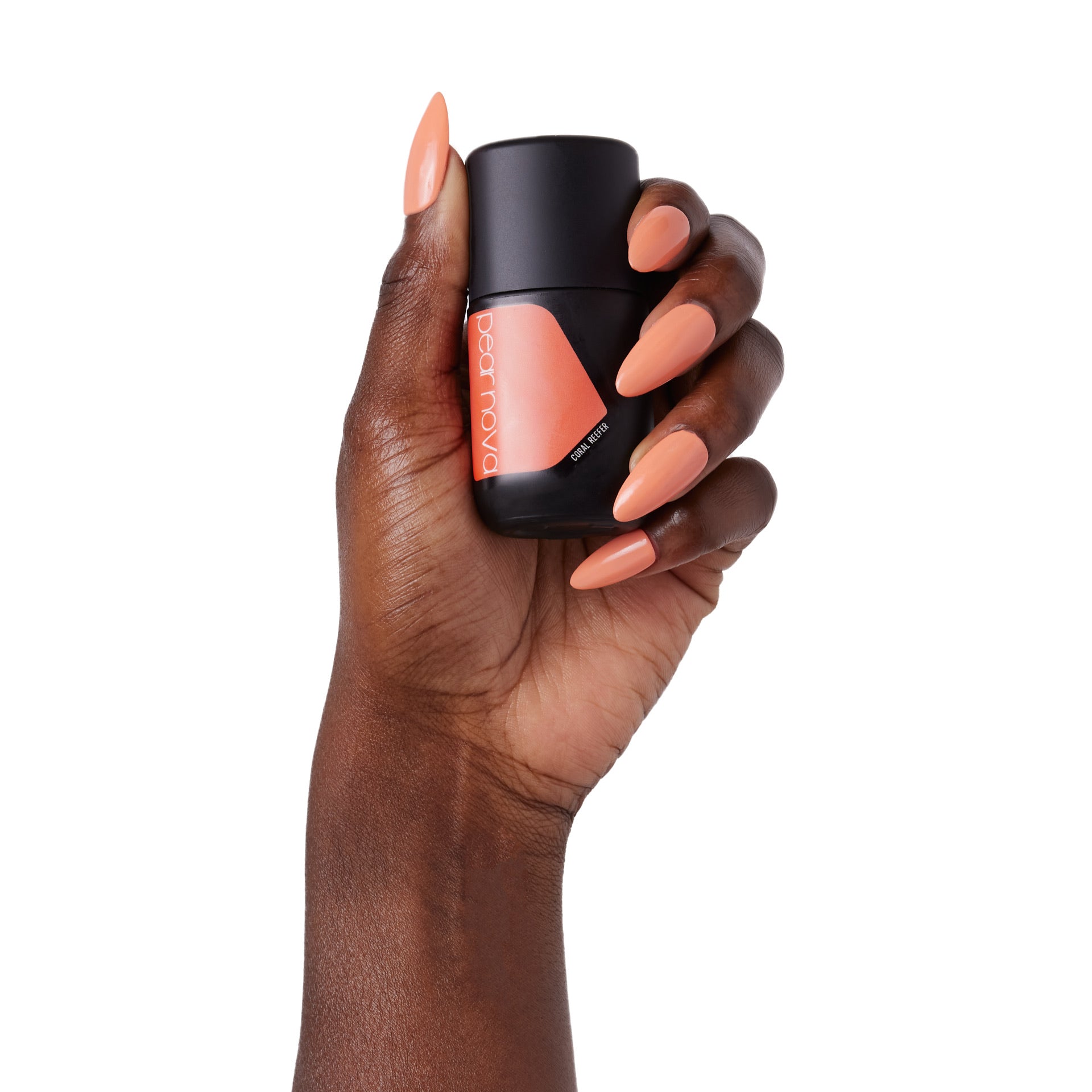 hand model holding bottle of nail lacquer with almond shaped Coral Reefer painted nails 