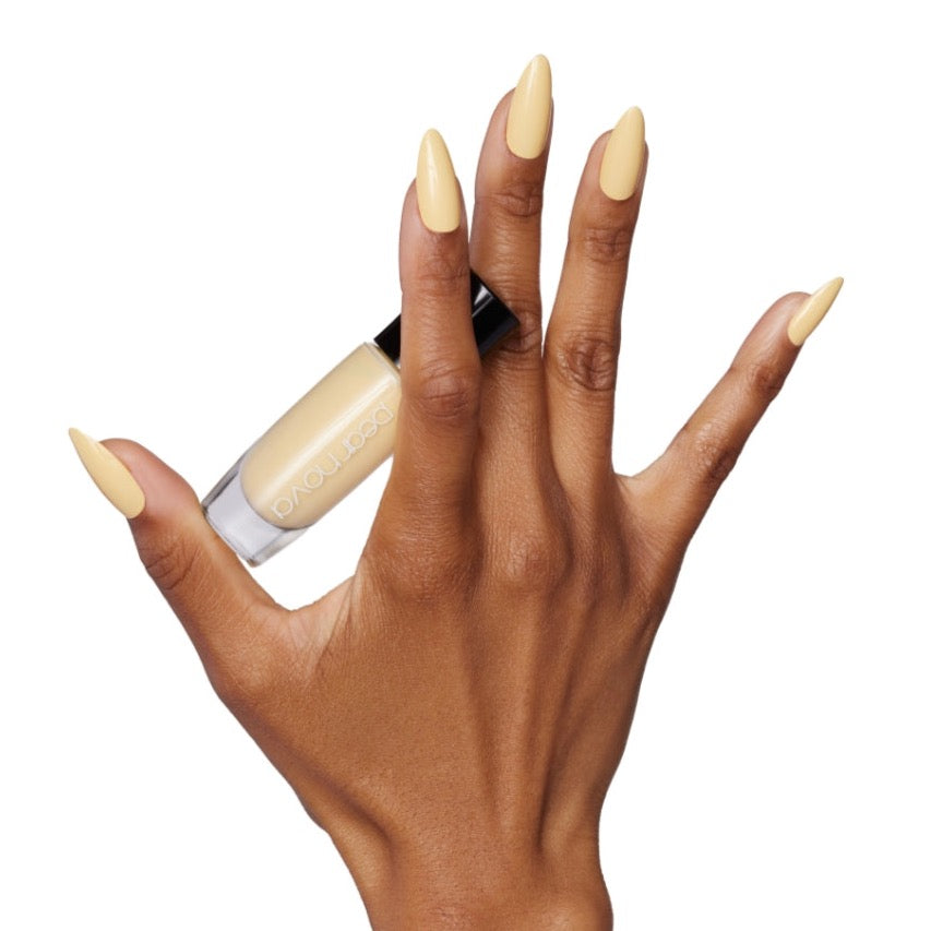 brown skin hand model holding bottle of nail lacquer with almond shaped Trip Around the Sun painted nails 