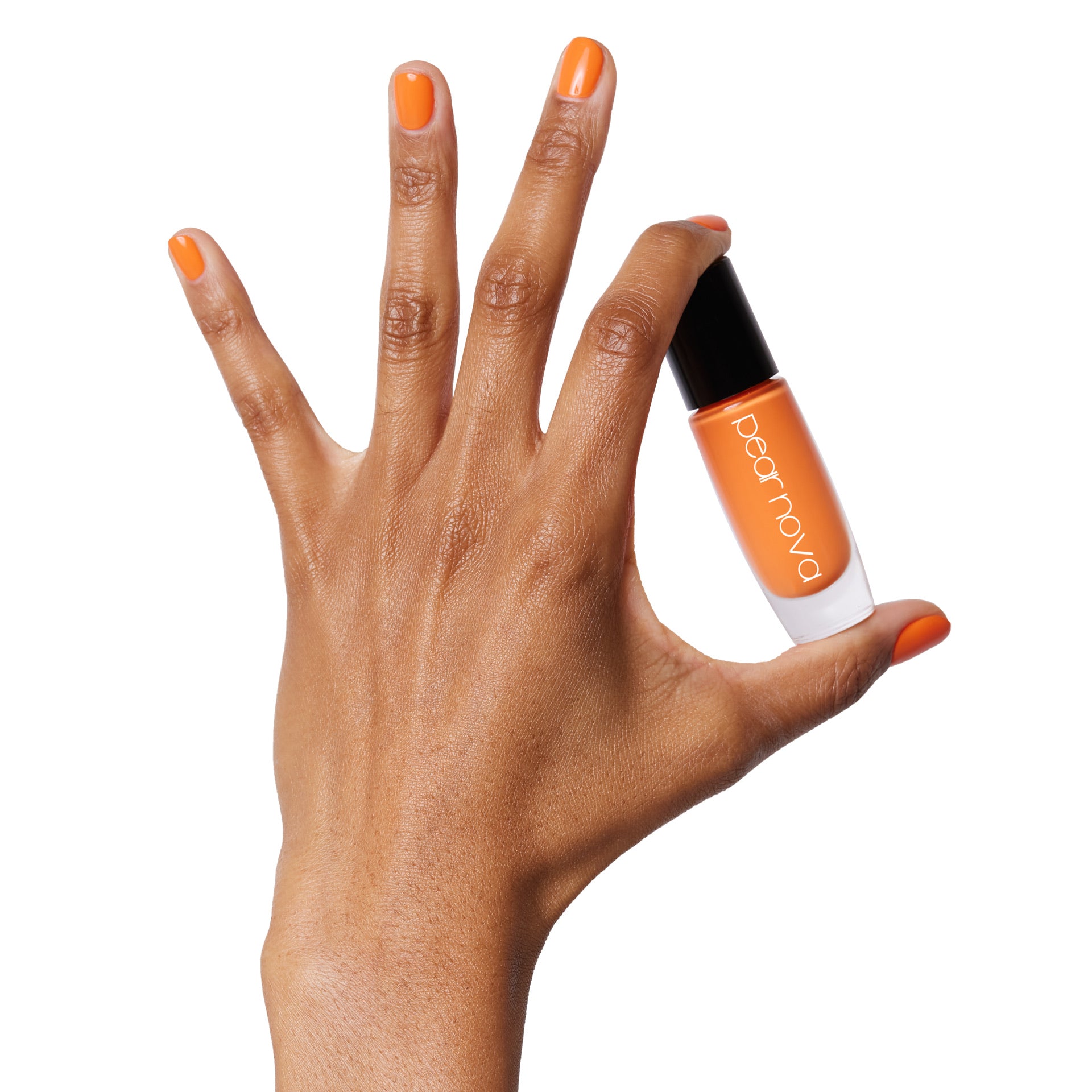 brown skin hand model holding bottle of nail lacquer with orange painted nails 