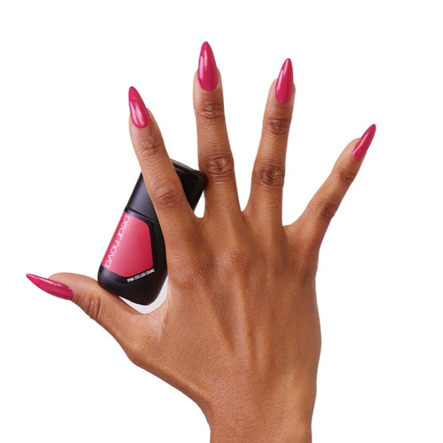 brown skin hand model holding bottle of nail lacquer with almond shaped bright pink painted nails in Pink Collar Crime