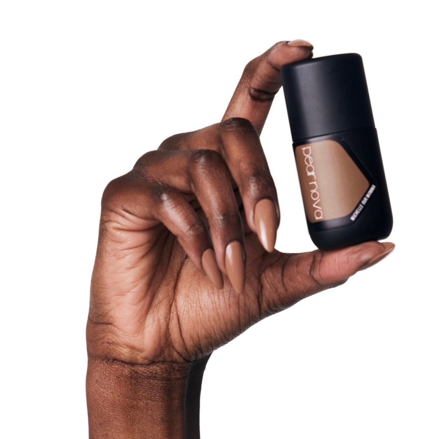 brown skin hand model holding bottle of nail lacquer with brown almond shaped painted nails 