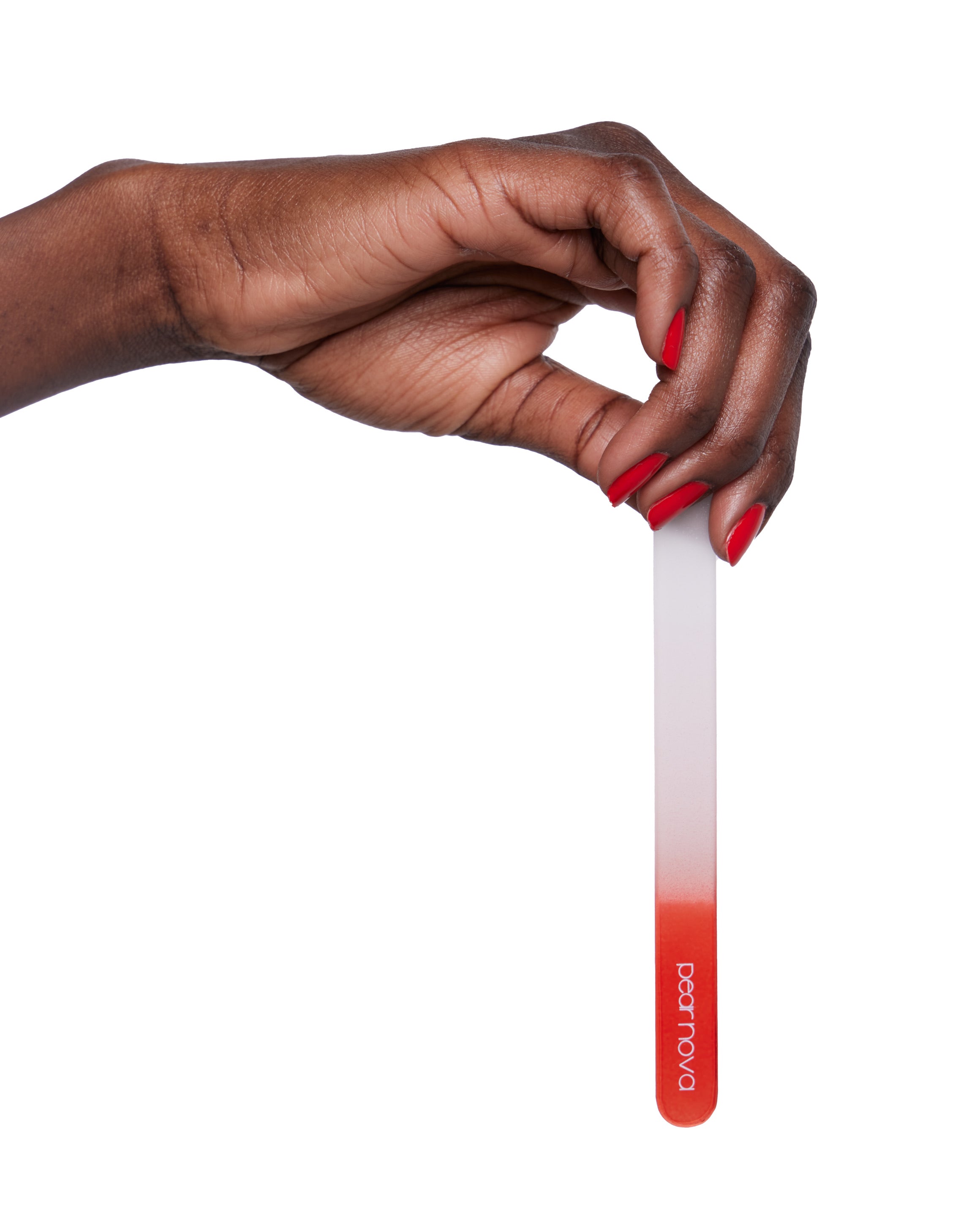 brown skin hand model with natural red nails holding a glass nail file 